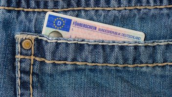 Un permis de conduire allemand dépasse de la poche d'un jean.