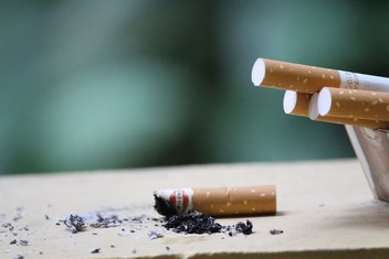 Achat de tabac transfrontalier : vue sur des cigarettes et un mégot de cigarette.