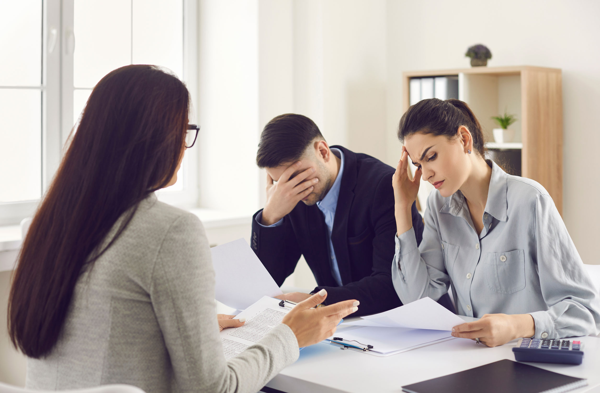 Un couple devant un banquière qui leur annonce qu'ils n'ont pas obtenu de prêt pour leur achat immobilier