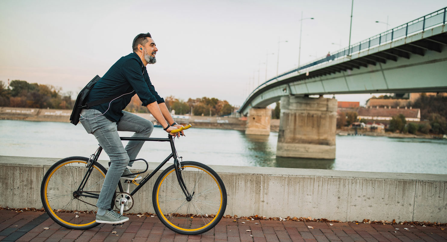 Un homme fait du vélo sur les quais d'une rivière en Allemagne