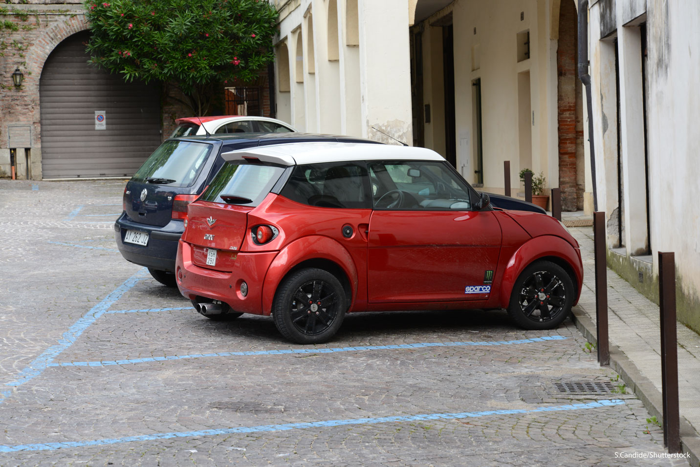 Une voiture sans permis rouge garée sur une place de stationnement