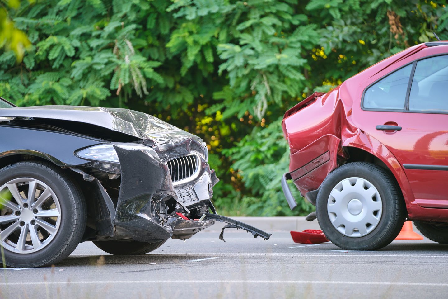 Une voiture noire a percuté l'arrière d'une voiture rouge sur une route