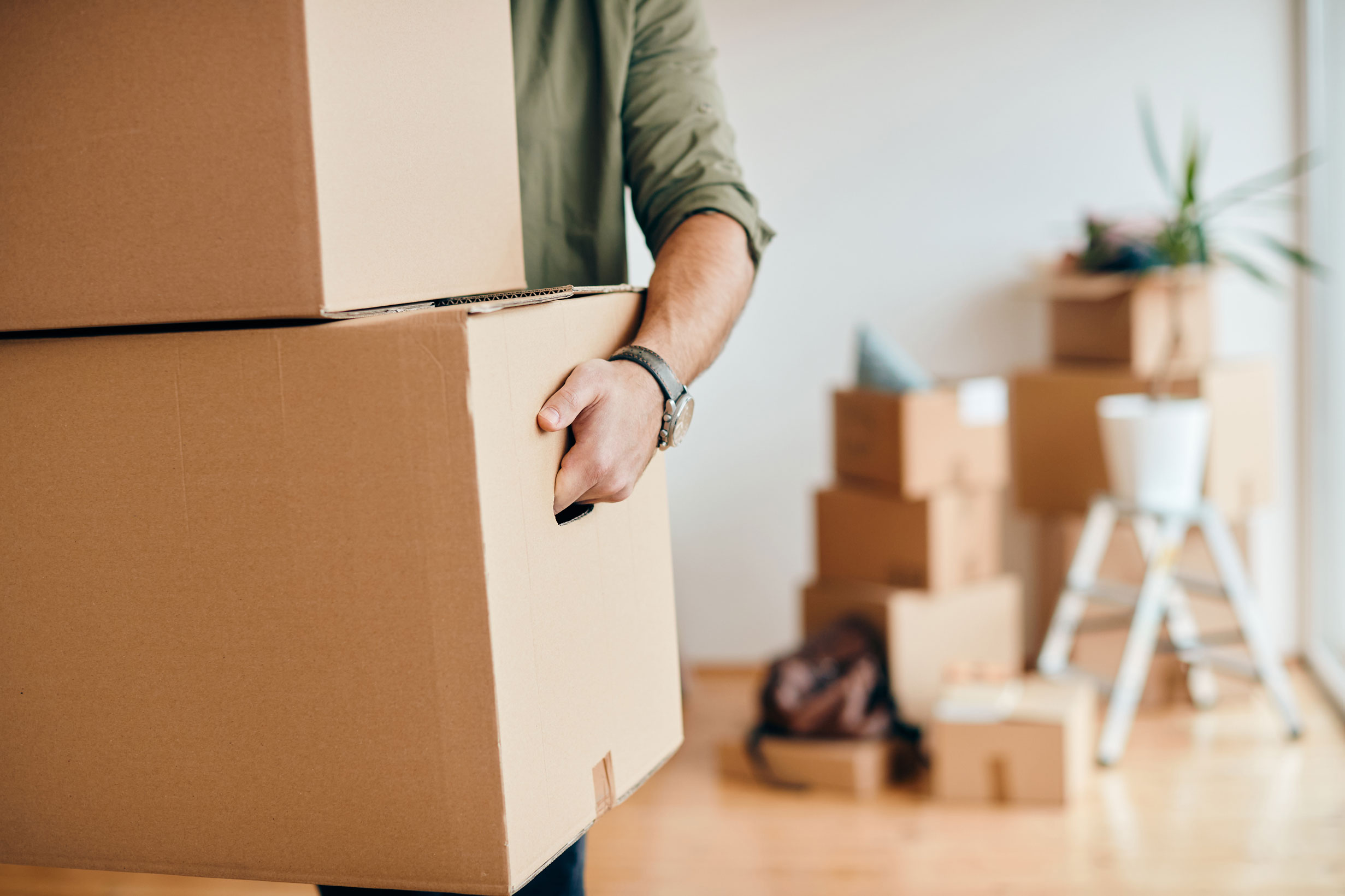 Une personne porte deux des cartons fermés avant un déménagement en Allemagne