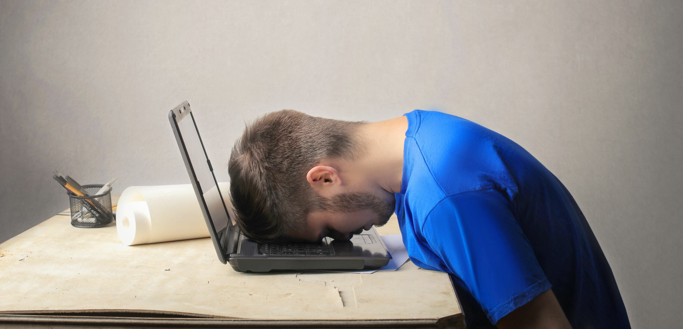 Frustrierter Mann mit Kopf auf der Tastatur.
