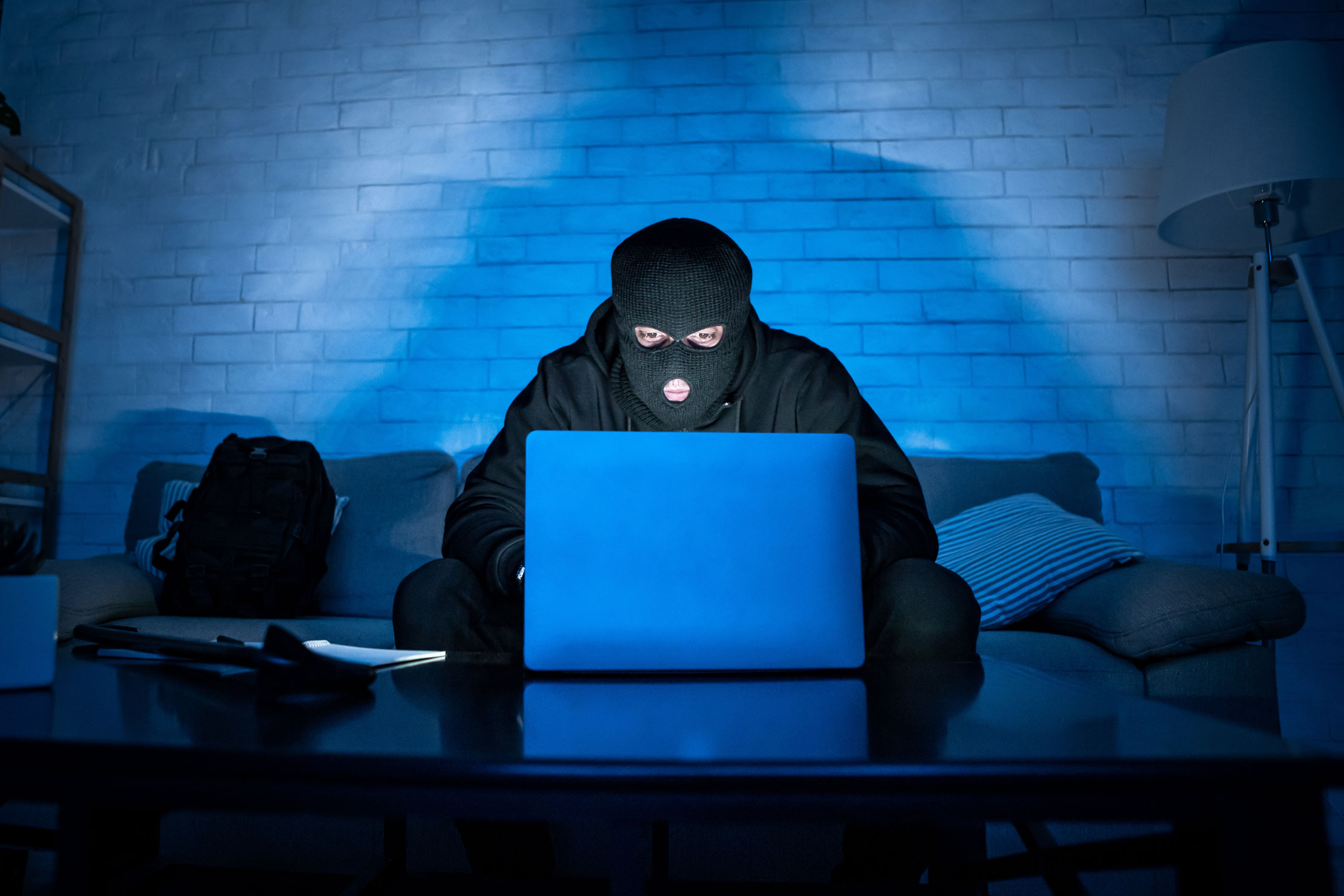 Une personne cagoulé dans le noir et devant un ordinateur, illustration pour le téléchargement illégal en Allemagne