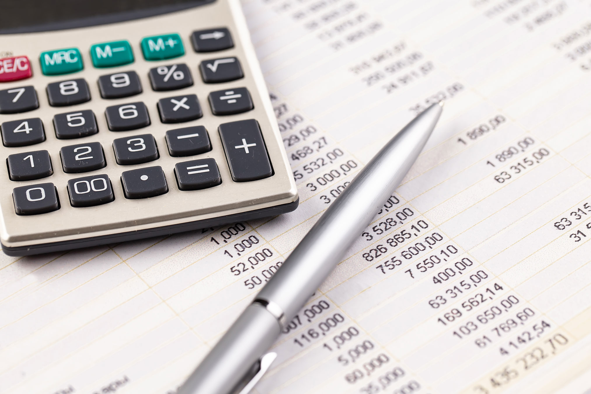 Illustration du calcul des impôts avec une calculatrice, un stylo et une fiche comptable comprenant, notamment, la CSG et la CRDS.