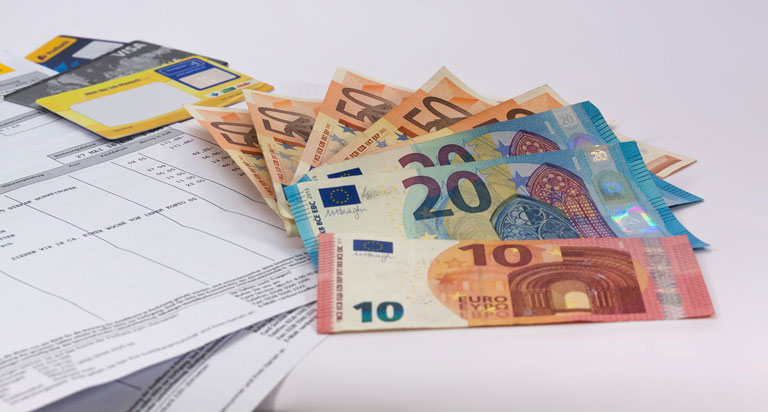 Rechnungsforderung für einen Einkauf. Auf einer Ablage sind mehrere Euro-Scheine ausgelegt.