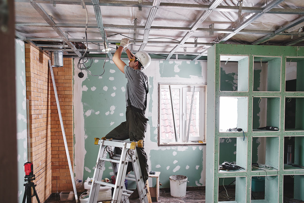 Un artisan réalise des travaux dans une maison