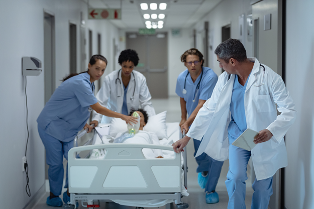 Quatre médecins urgentistes d'un hôpital transportent un patient allongé dans un brancard