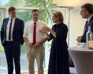 Bundesministerin Dr. Stefanie Hubig spricht mit Jakob Thevis, dem Bundestagsabgeordneten Dr. Johannes Fechner und dem Landrat des Ortenaukreises Thorsten Erny