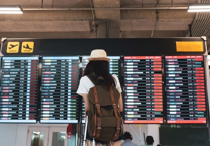 Eine Frau schaut auf die Anzeigetafel am Flughafen.