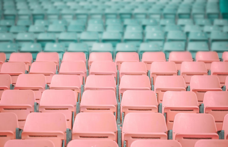 Sièges colorés vides dans un stade.