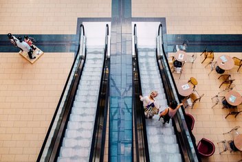 Vue de haut d'un escalator dans un centre commercial.
