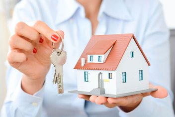 Eine Immobilienmaklerin hält einen Schlüsselbund in der Hand.
