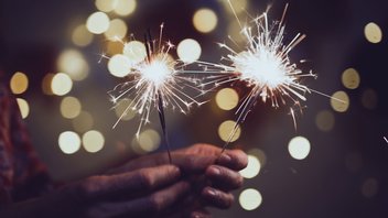 Deux mains tiennent des articles pyrotechniques comme des pétards ou feux d'artifice pour des festivités comme le Nouvel an. 