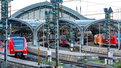 Trois trains rouge stationnés dans une gare d'Allemagne. Pour traverser l'Allemagne pendant l'Euro 2024 de football en Allemagne, le train peut être une bonne alterntive.