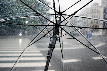 De la pluie coule le long d'un parapluie