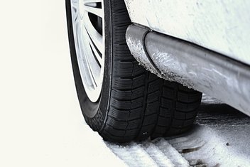 Un gros plan sur le pneu d'une voiture dans la neige.