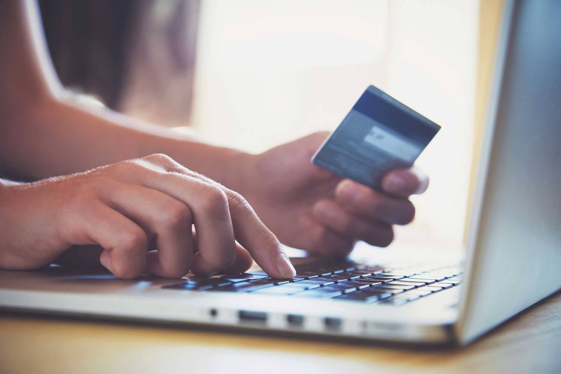Eine Person kauft mit ihrer Kreditkarte einen Artikel in einem Online-Shop. 